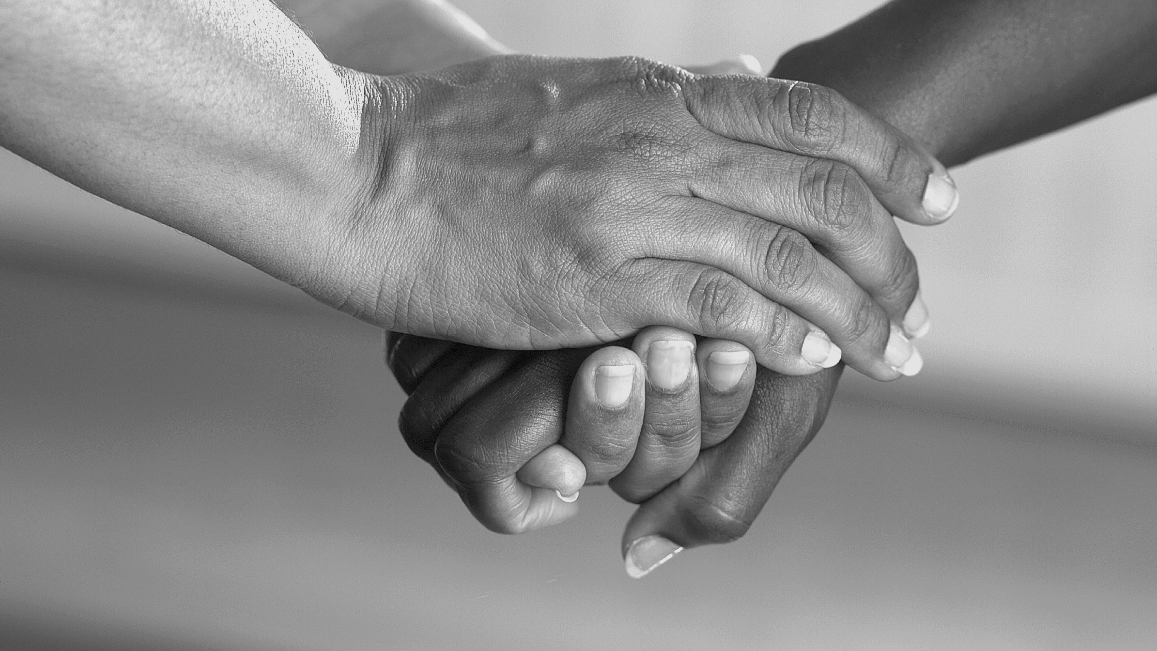 Black and white image of two hands holding.