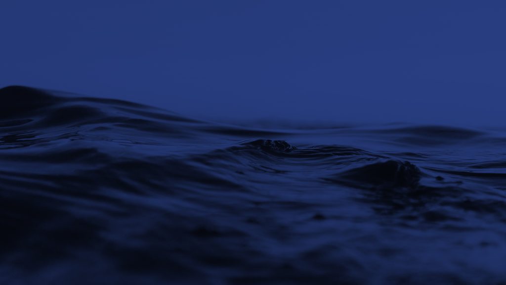 Ripples in a body of water. The entire photo has a dark blue tint overlay.